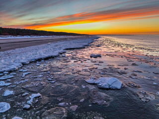 Beautiful sunset over the frozen Baltic Sea beach in Jantar, Poland