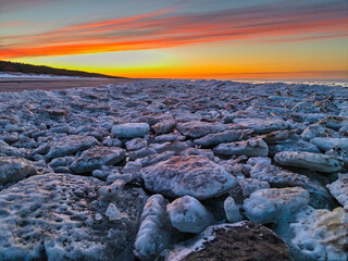 Beautiful sunset over the frozen Baltic Sea beach in Jantar, Poland