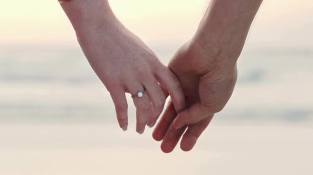 Close-up of Engaged Couple Holding Hands with Diamond Ring on Beach. life partner walk with the beauty of  nature 
