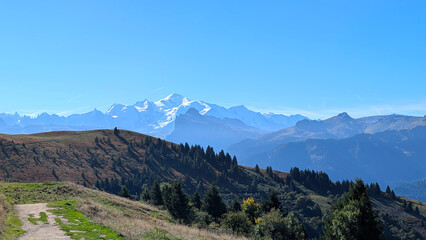 Fototapeta premium Panoramic view of Mont Blanc mountain seen from Bourgeoise above Samoens in French Alps. Landscape concept captures alpine scenery, vast horizon, clear sky, natural grandeur.