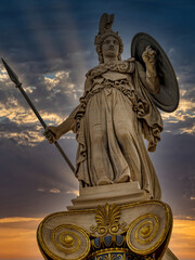 Fototapeta premium Ancient Athena statue towers over Athens in warm evening light, a timeless symbol of strength, intelligence, and classical civilization.