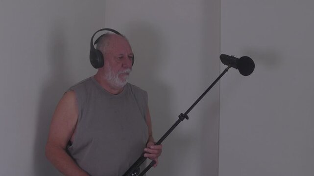 A focused boom operator wearing headphones holds a microphone boom pole in a studio environment. ideal for use in media, entertainment, and educational content.