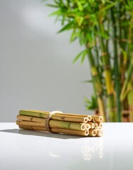 Fototapeta premium Bundle of Natural Bamboo Straws with Green Bamboo Stalks in Background Sunlight