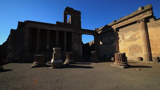 Travel back in time. Remains of Pompeii's Macellum provision market on the Forum: scattered tuff column bases around courtyard.
