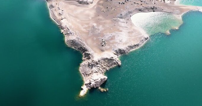 Aerial shot of exposed sediment banks and turquoise reservoir water Spain drought environment