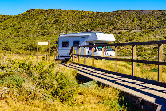 Wooden path on beach with camper camping on coast