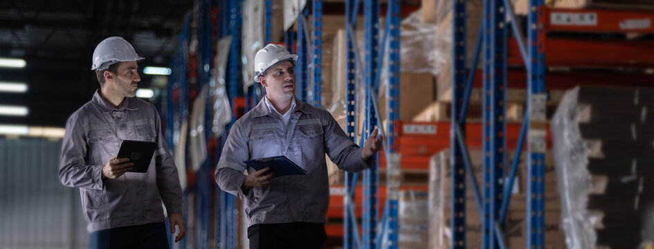 Warehouse team inspecting inventory and discussing stock management in distribution center, workers using tablet and clipboard, logistics operation, supply chain coordination and warehouse control.