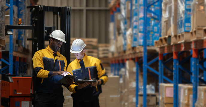 Warehouse workers reviewing inventory data using tablet and clipboard, stock inspection and audit process in storage facility, logistics operation, supply chain management and teamwork concept.