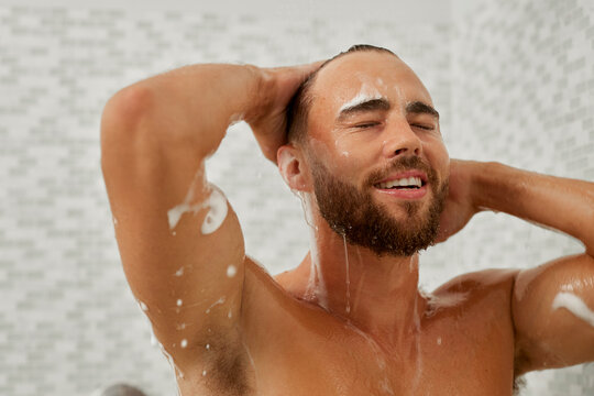Man taking a shower and shampooing hair