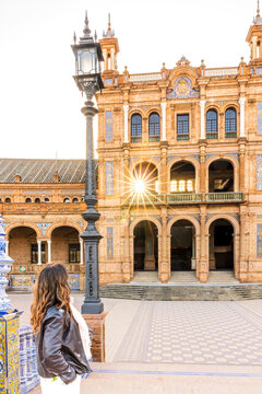 Travel, tourism: Woman looks at the architecture of Plaza de Espa&ntilde;a in Seville, Spain, enjoying the outdoor environment. Plaza de Espa&ntilde;a, Seville, Spain.