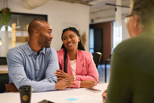 Happy black couple consulting bank agent for their savings