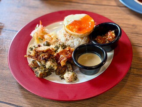 Filipino pork silog served with fragrant cilantro rice, spicy sambal, and sunny side up fried egg. A hearty and flavorful comfort food dish, perfect for breakfast, brunch, or casual dining content. C