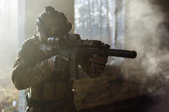 Special forces soldier with skull mask and carbine in abandoned building