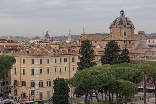 Elevated view from Capitoline Hill showing Rome architecture, Italian pine trees and the dome of Santa Maria in Aracoeli. Calm city scene in cloudy weather.