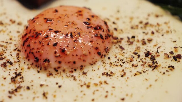 A close-up of a fried egg seasoned with ground allspice, a healthy and filling breakfast. High quality 4k footage