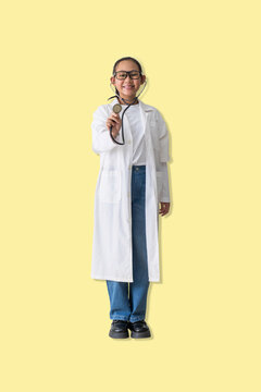 Happy young woman  dressed as a doctor holds out a stethoscope, symbolizing care, trust, and a friendly approach to healthcare and medical checkups