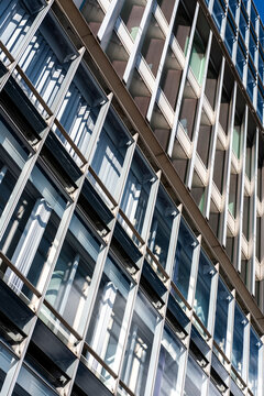 Abstract blue facade architecture in exterior perspective with modern windows grid and repeating pattern presenting contemporary geometry on an office building