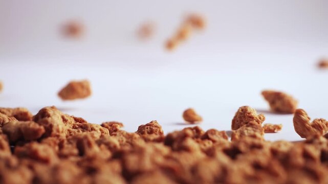 Pieces of soy meat fly toward the camera in sharp focus. A dynamic close-up, a concept for plant-based protein and vegan food. High quality 4k footage