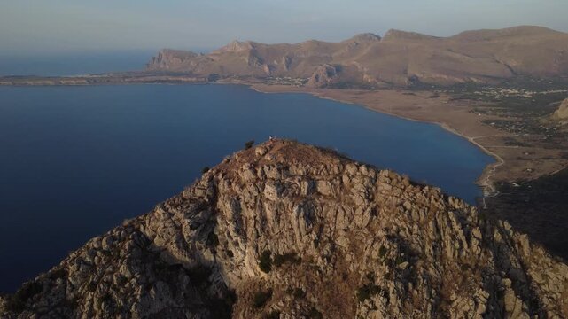 Drohnenaufnahme eines Berges mit Klippen und Meer in Sizilien