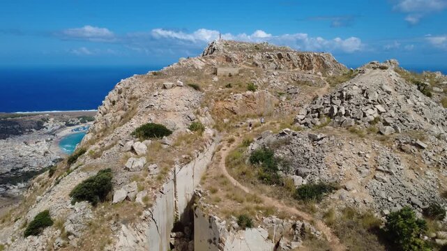 Drohnenaufnahme eines Berges mit Klippen und Meer in Sizilien