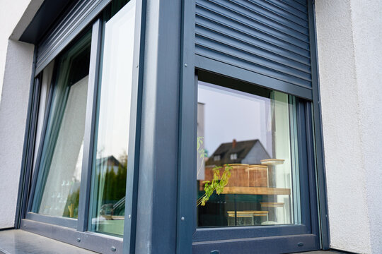 Close up of modern house window with roller shutter over glass on exterior facade. Concept of residential architecture, home design and property detail