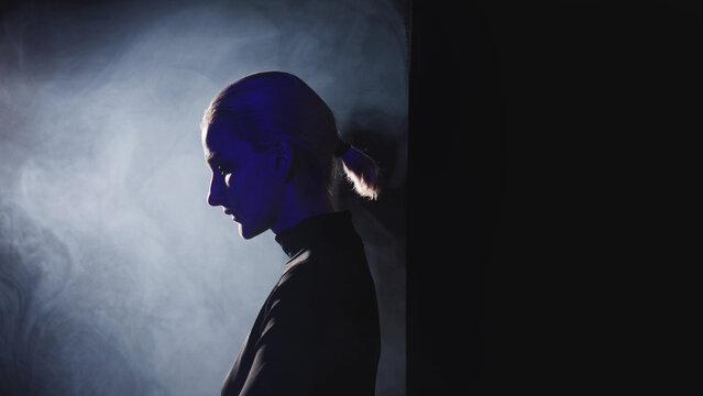 Blonde woman stepping into light beam, public expression
