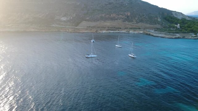 Luftaufnahme von Segelyachten in einer t&uuml;rkisfarbenen Bucht vor der K&uuml;ste von Favignana, Sizilien