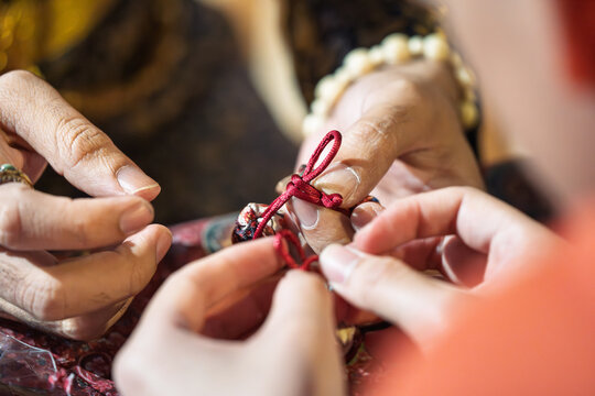 Close up of Thai traditional red string keychain making process