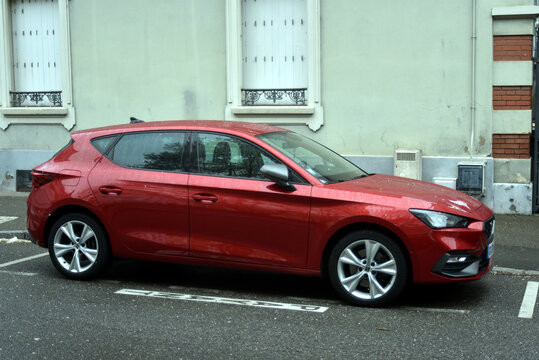 Mulhouse - France - 29 March 2026 - profile view of red Seat Leon parked in the street
