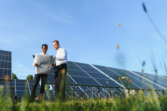 Diverse engineers planning renewable solar energy project