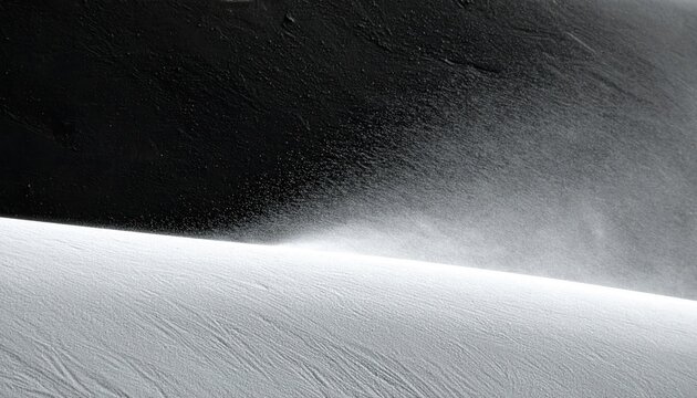 Paysage hivernal minimaliste en noir et blanc montrant de la neige souffl&eacute;e par le vent sur une cr&ecirc;te de montagne avec un contraste saisissant.