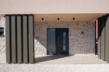 Naklejka premium Modular modern smart automated house entrance with stone facade and minimalist covered porch in progress