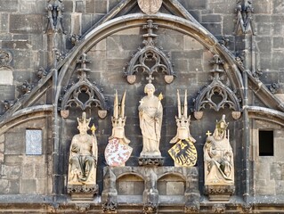 Ornate carved stone figures and shields evoke deep cultural heritage narratives throughout architecture © Vladimir