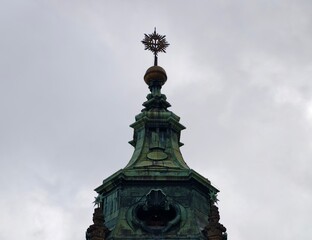 Ornate dome with decorative elements. Crowned cupola under cloudy sky with intricate copper carvings © Vladimir