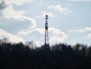 Obraz premium Rural tower backdrop. Silhouette of transmission mast in natural landscape under dramatic sky
