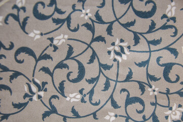 Vintage floral pattern on fabric texture. Elegant blue and white leaf vine motif on gray textile background. Classic ornamental design for fashion and decor. © Setyotuhu