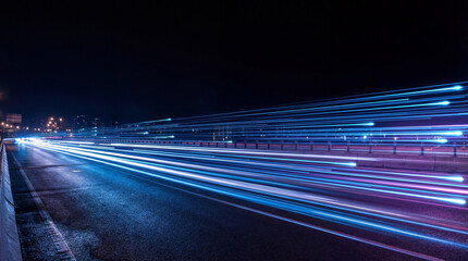 Long exposure photograph of vibrant blue and purple light trails on a highway at night. © Jacqueline