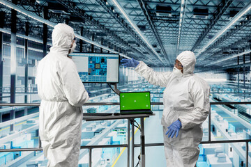 Fototapeta premium Green screen laptop, improving machinery speed and energy efficiency and engineers in microchip factory. Optimizing semiconductor production process, mockup notebook and experts