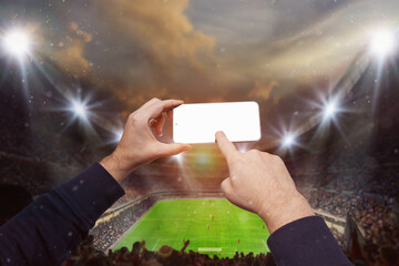  Hands holding smartphone with blank screen on epic soccer stadium with participants glowing. ready for game