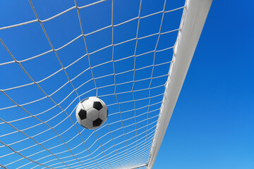  Soccer ball in soccer goal net in a big stadium isolated on blue sky. soccer net.