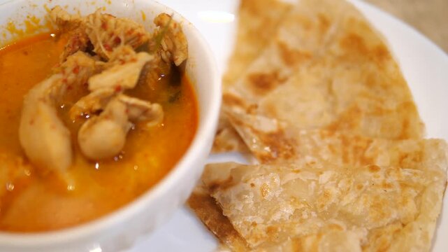 Crispy flatbread roti served with authentic Thai chicken Panang curry for Asian restaurant and fusion food concept