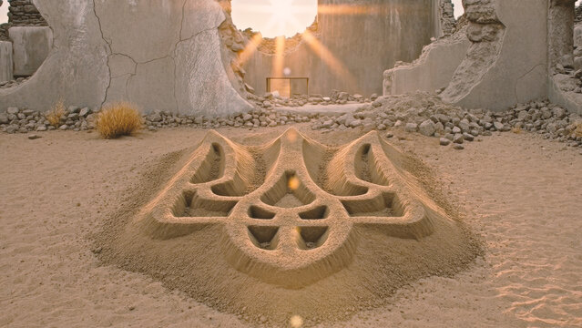 Symbolic Ukrainian Trident Sand Sculpture in War Ruins Under Golden Sun Rays, Resilience and Hope Concept