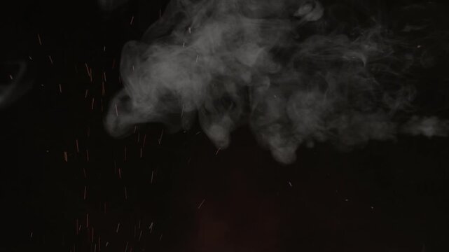 Ethereal smoke and ember particles rising against a deep black background