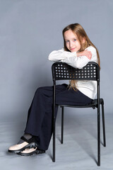 Fototapeta premium A peaceful scene, with a child leaning on a chair, exuding serenity and a homely feel.