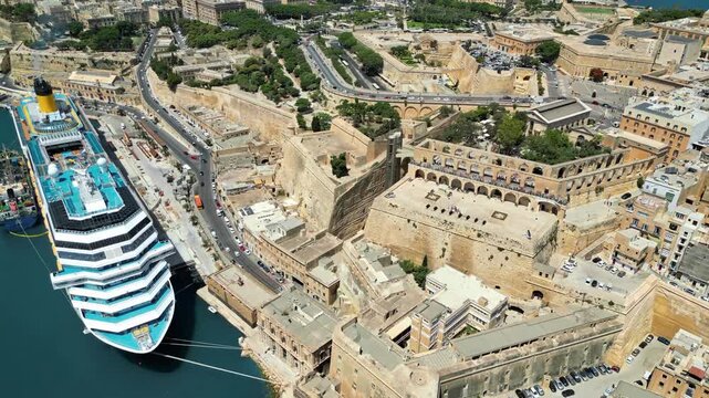 Aerial view of valletta city with cruise ship docked at grand harbor showing maltese architecture.