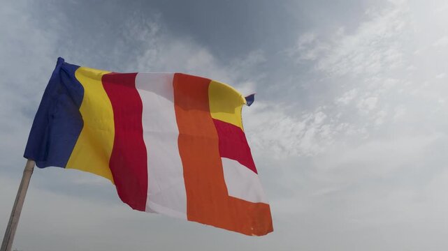 Buddhist Flag Fluttering: Capturing the serene flutter of the iconic Buddhist flag against a sky.