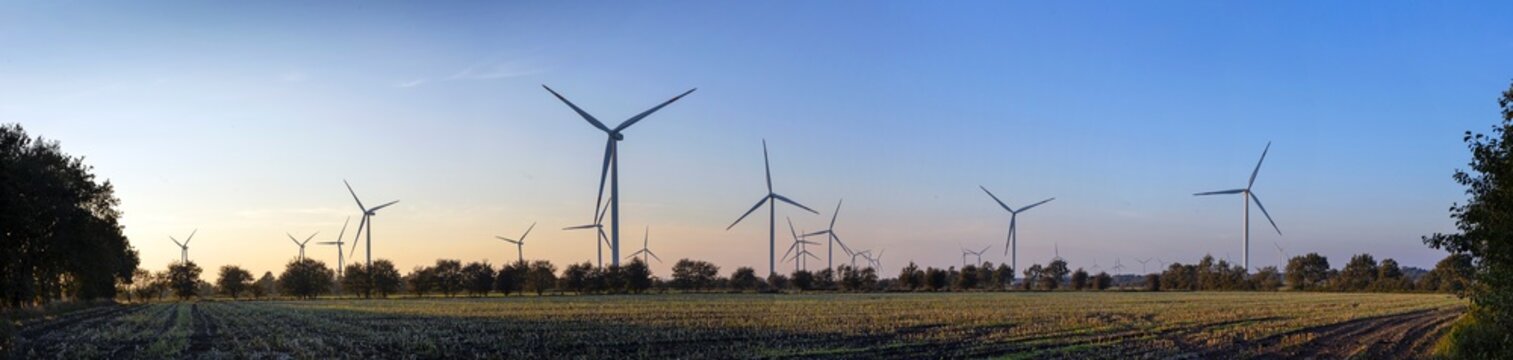 Landscape with windturbines in rural landscapes in Germany at sunset. Green and sustainable energy.