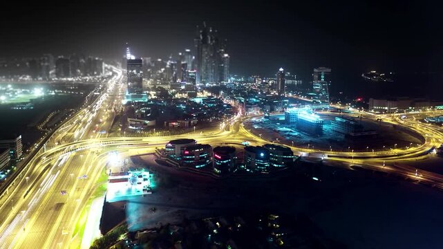 Time-lapse footage of a vibrant modern city at night, featuring illuminated highways converging in a circular pattern surrounded by brightly lit skyscrapers.
