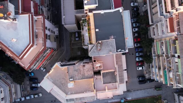 High altitude top down drone view flying over residential buildings and city streets in thessaloniki