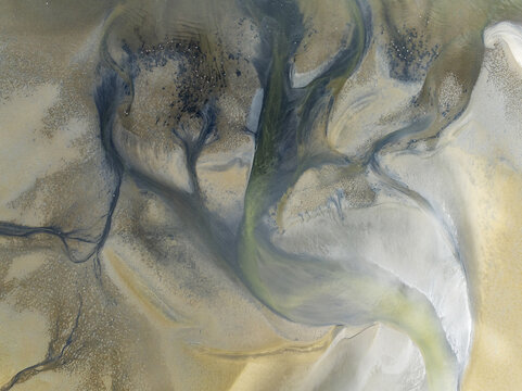 Aerial view of an abstract painting of swirling greens and blues blending into the sandy shorelines, Walvis Bay, Erongo Region, Namibia.